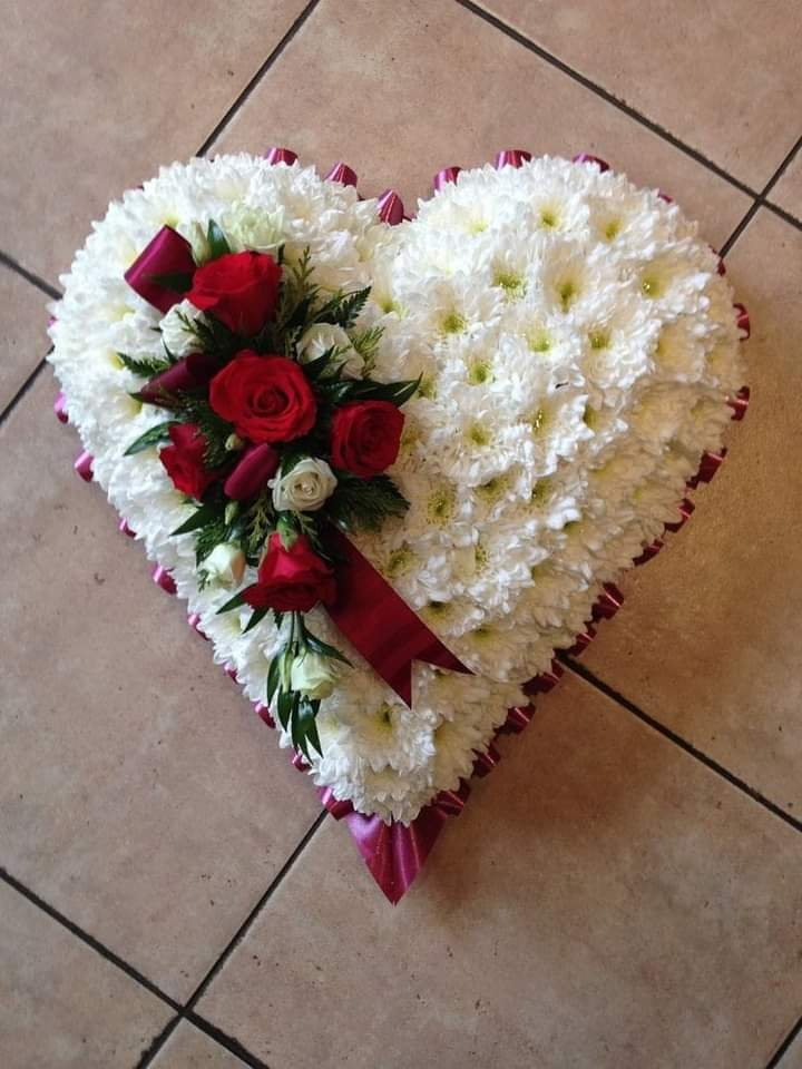 Corazón fúnebre blanco con rosas rojas